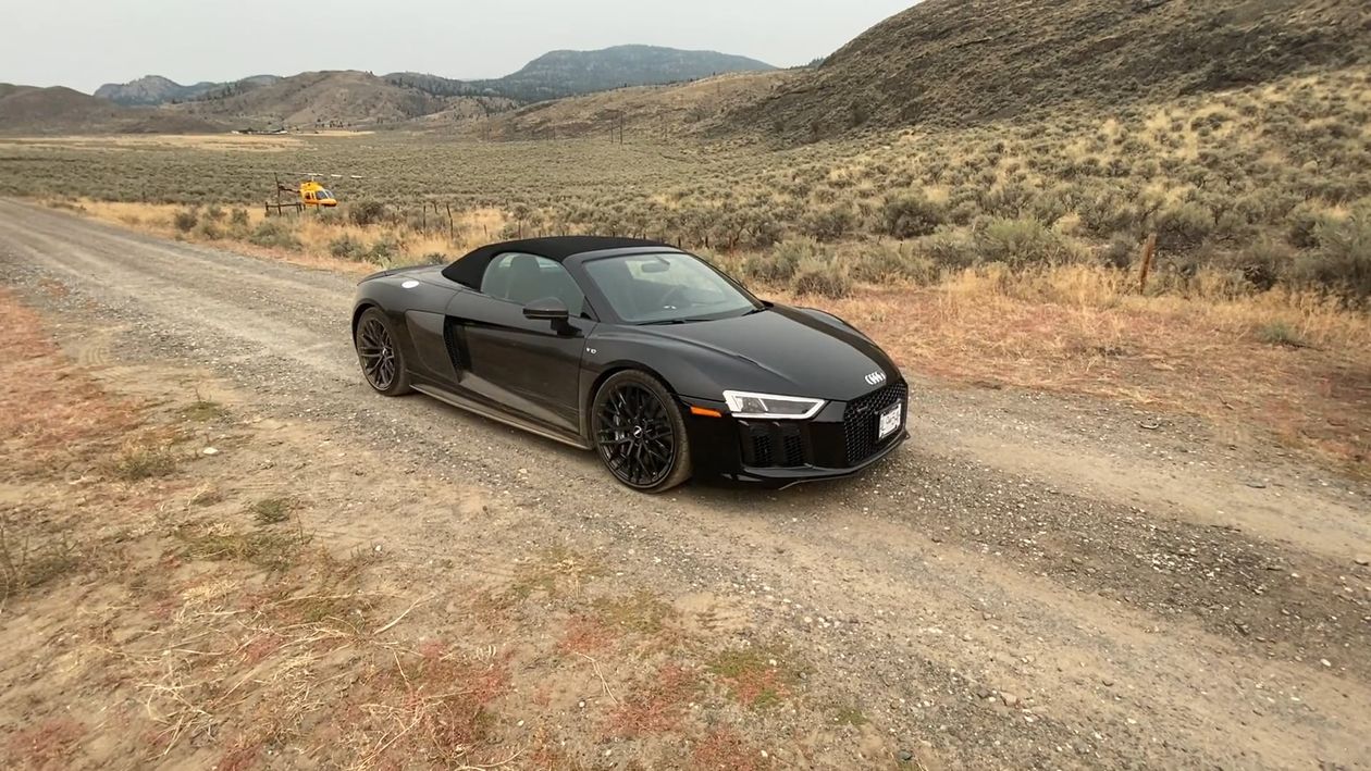 Black sports car against warm desert dunes